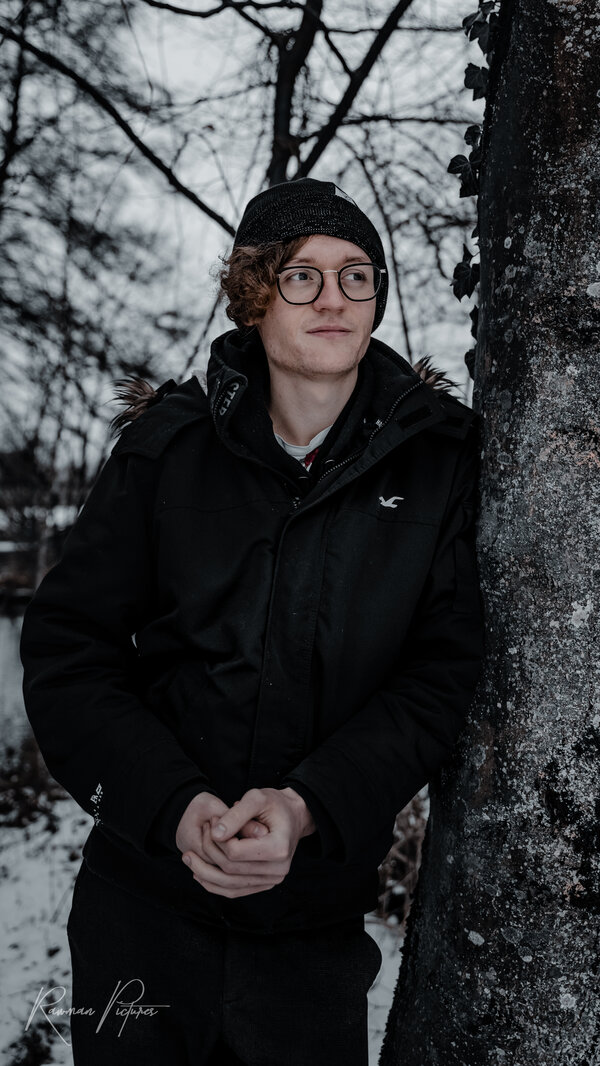 RawmanPictures - Sebastian Schiefermayr | Wintershooting Maximilian W. | Portrait im Winterwald, Mann mit Brille, warme Kleidung, Fotografie im Freien.