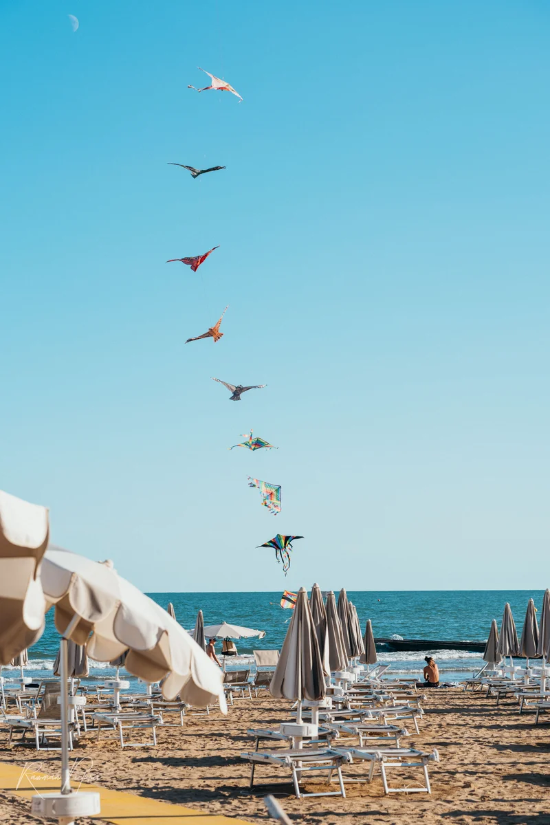 RawmanPictures - Sebastian Schiefermayr | Urlaub Jesolo | Drachen am Strand: Perfekte Balance zwischen Himmel, Meer und Freizeitspaß in der Naturfotografie.